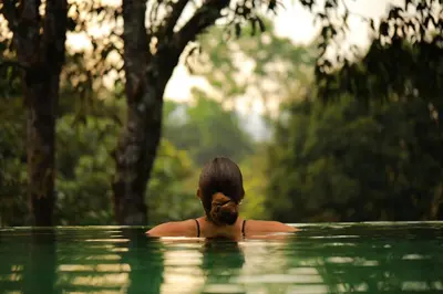 a woman sitting in a pool of water at Wayanad Wild - A CGH Earth Experience in Vythiri