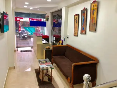 a living room with a couch and a table at Hotel Landmark in Ooty