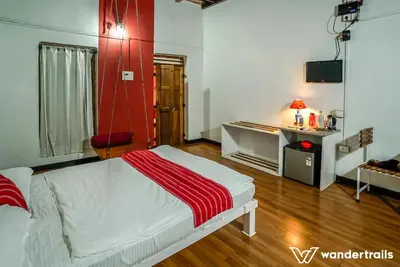 a bedroom with a bed with a red wall at Teak Town in Nilambūr