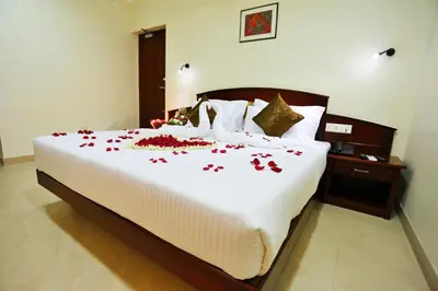 a bedroom with a large bed with roses on it at Hotel White City in North Paravur
