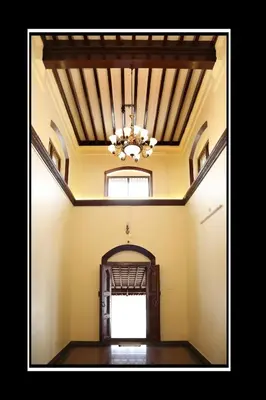 an empty room with a chandelier hanging from the ceiling at Pattiah Naidu Palace in Palani