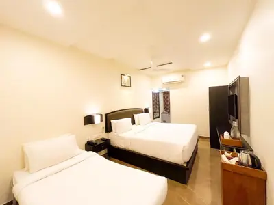 a hotel room with two beds and a tv at Shree Residency in Erode