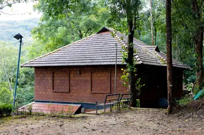 a small brick building with a bench in front of it at Green Garden Jasmin Cottage in Vayittiri