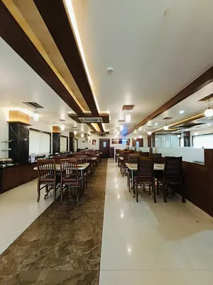 a dining room with tables and chairs in it at Holiday Residency Coimbatore in Coimbatore
