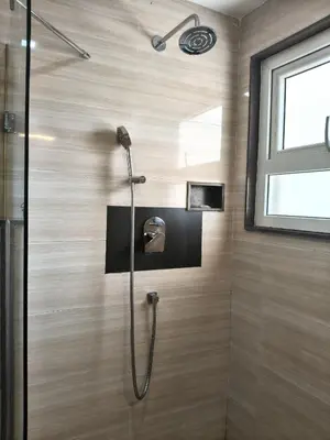 a shower with a glass door in a bathroom at Holiday Residency Coimbatore in Coimbatore