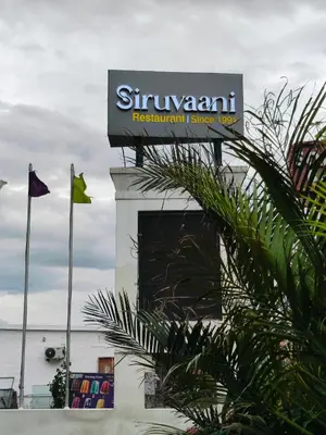 a sign on top of a building with flags at Holiday Residency Coimbatore in Coimbatore