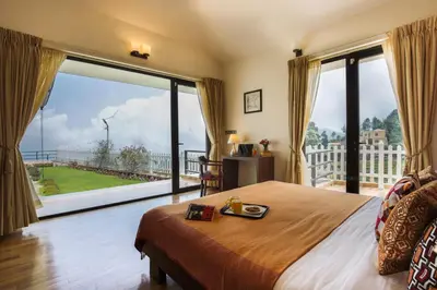 a bedroom with a bed and a large window at The Xanadu, Coonoor in Coonoor