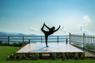 a woman doing a yoga pose on top of a table at The Xanadu, Coonoor in Coonoor
