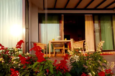 a living room with a table and red flowers at The Xanadu, Coonoor in Coonoor