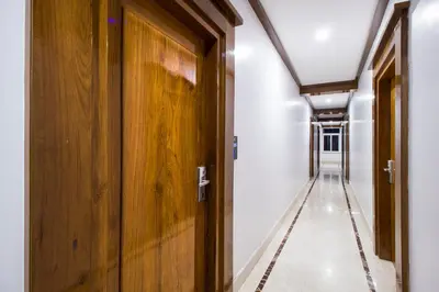 an empty hallway with a wooden door and a hallwayngth at Hotel Lok Sagar Mysore in Mysore