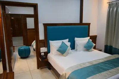 a bedroom with a bed with a blue headboard at Hotel Lok Sagar Mysore in Mysore