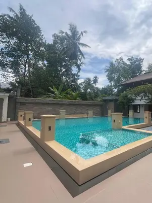 a large swimming pool in the middle of a building at Coconut Garden in Cherai Beach