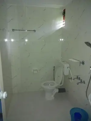 a white bathroom with a toilet and a shower at Coconut Garden in Cherai Beach