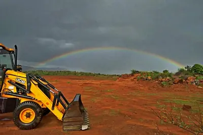 a yellow tractor with a rainbow in the background at Green Peace Bheemeshwari in Halgūr