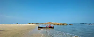 two people standing in a boat on the beach at White Shell Beach House in Kannur