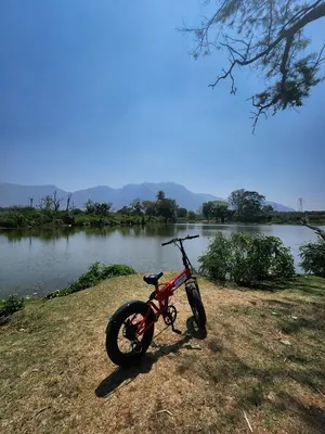 a dirt bike parked next to a body of water at Wildways Mudumalai Homestay in Masinagudi