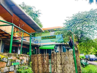 a building with a sign on the side of it at Wildways Mudumalai Homestay in Masinagudi