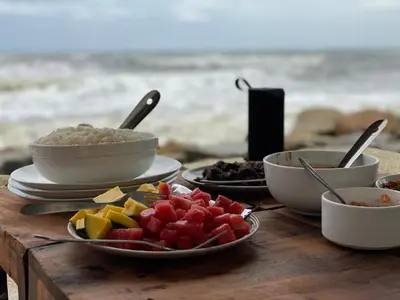 a table with bowls of food and fruit on it at Cherai Onetree Retreat in Cherai Beach
