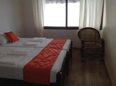 a bedroom with a bed and a chair and a window at Cherai Onetree Retreat in Cherai Beach
