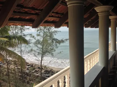 a view of the beach from the porch of a beach house at Cherai Onetree Retreat in Cherai Beach