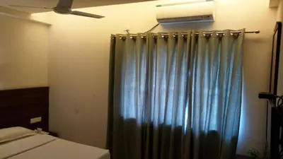 a bedroom with a bed with a curtain and a fan at Nalanda Inn in Palakkad