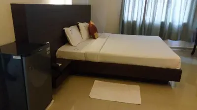 a bedroom with a bed with a black headboard at Nalanda Inn in Palakkad