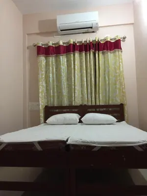 a bed in a room with a window with a heater at Mega Tourist Home in Guruvāyūr