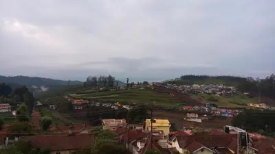 a town on top of a hill with houses at Drizzle Drop Inn in Ooty