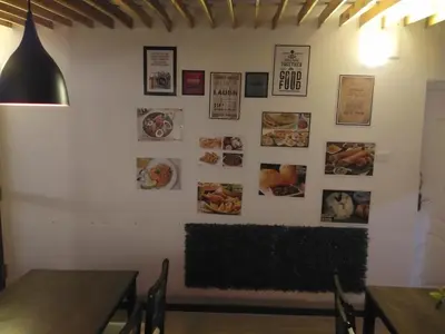 a dining room with tables and pictures on the wall at Drizzle Drop Inn in Ooty
