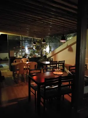 a dining room with tables and chairs and a bar at Drizzle Drop Inn in Ooty