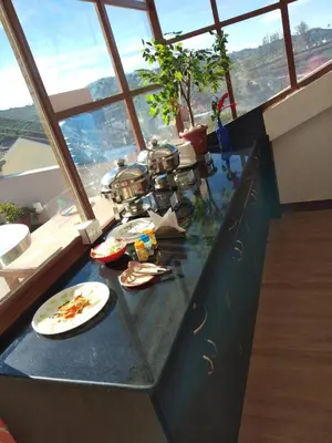 a kitchen with a counter with plates of food on it at Drizzle Drop Inn in Ooty