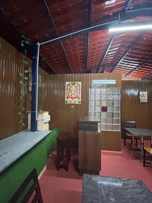 a restaurant with wooden walls and tables and benches at Hotel Jothi in Coimbatore