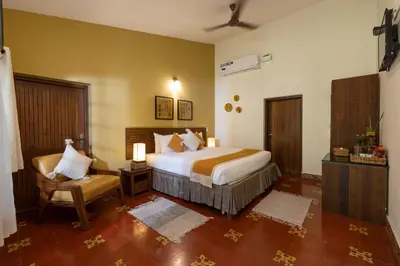 a bedroom with a bed and a chair in it at The Mangifera in Bandipūr