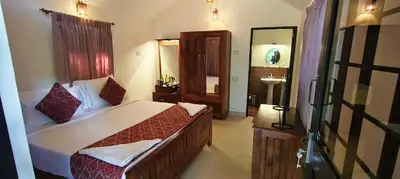 a bedroom with a large bed and a sink at Monica Garden Bungalow in Vālpārai