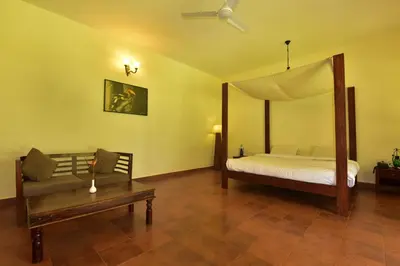 a bedroom with a bed and a couch in a room at Monica Garden Bungalow in Vālpārai