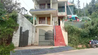 a house with a gate and a red staircase at Skylarc Inn in Ooty
