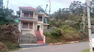 a house with a gate on the side of a road at Skylarc Inn in Ooty