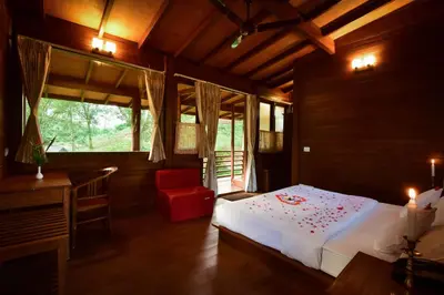 a bedroom with a bed and a desk and a window at Sirukundra Garden Bungalow in Vālpārai