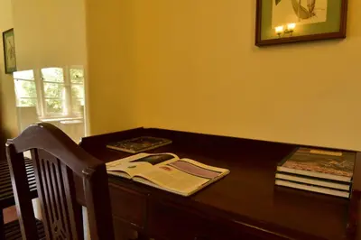 a wooden desk with a book on top of it at Sirukundra Garden Bungalow in Vālpārai