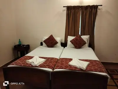 a bedroom with two beds with pillows on them at Puthuthottam Annexe in Vālpārai