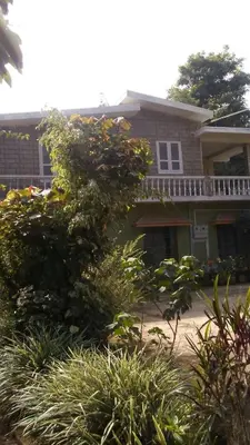 a house with a bunch of plants in front of it at Hill side estate in Madikeri