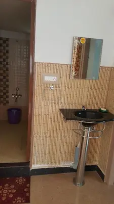 a bathroom with a sink and a mirror on the wall at Hill side estate in Madikeri