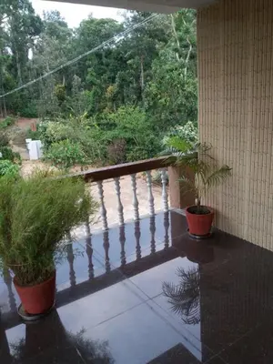 a balcony with two potted plants on a porch at Hill side estate in Madikeri