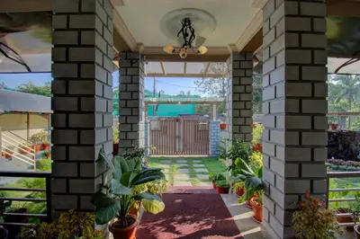 a house with a courtyard with plants at Srinikethana Home Stay with Swimming Pool in Madikeri