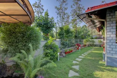 a garden with plants and a fence at Srinikethana Home Stay with Swimming Pool in Madikeri