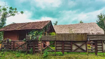 an old farm house with a thatched roof at Deshadan Eco Valley Resort - An Eco friendly Mud House in Kanthalloor