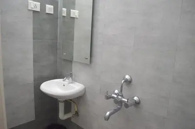 a bathroom with a sink and a mirror at Blackroots Serviced Apartments in Coimbatore