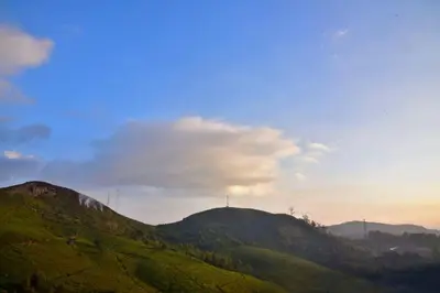 a view of a green hill with a blue sky at Mist Resorts Ooty in Ooty