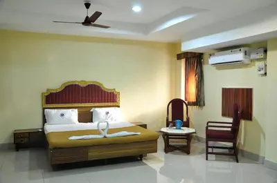 a hotel room with a bed and a chair at Hotel Chanma International in Coimbatore