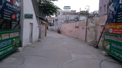 an alley with a person riding a motorcycle on a street at Hotel Chanma International in Coimbatore